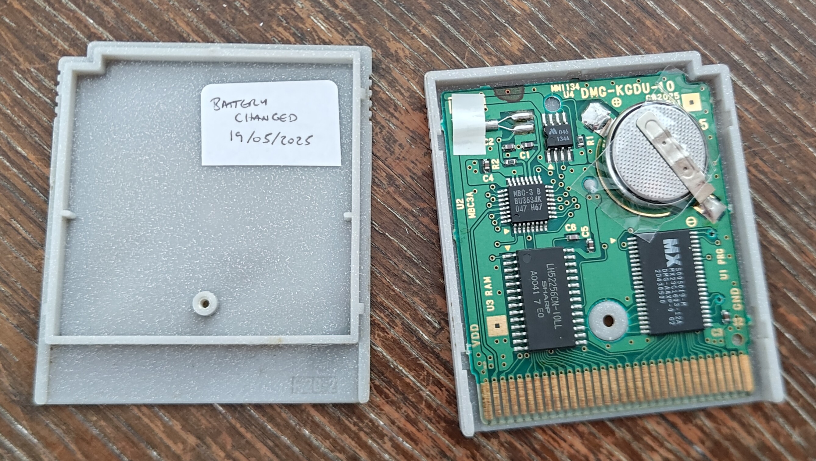 The open Pokémon Silver cartridge - a new, thicker battery is taped between the tabs