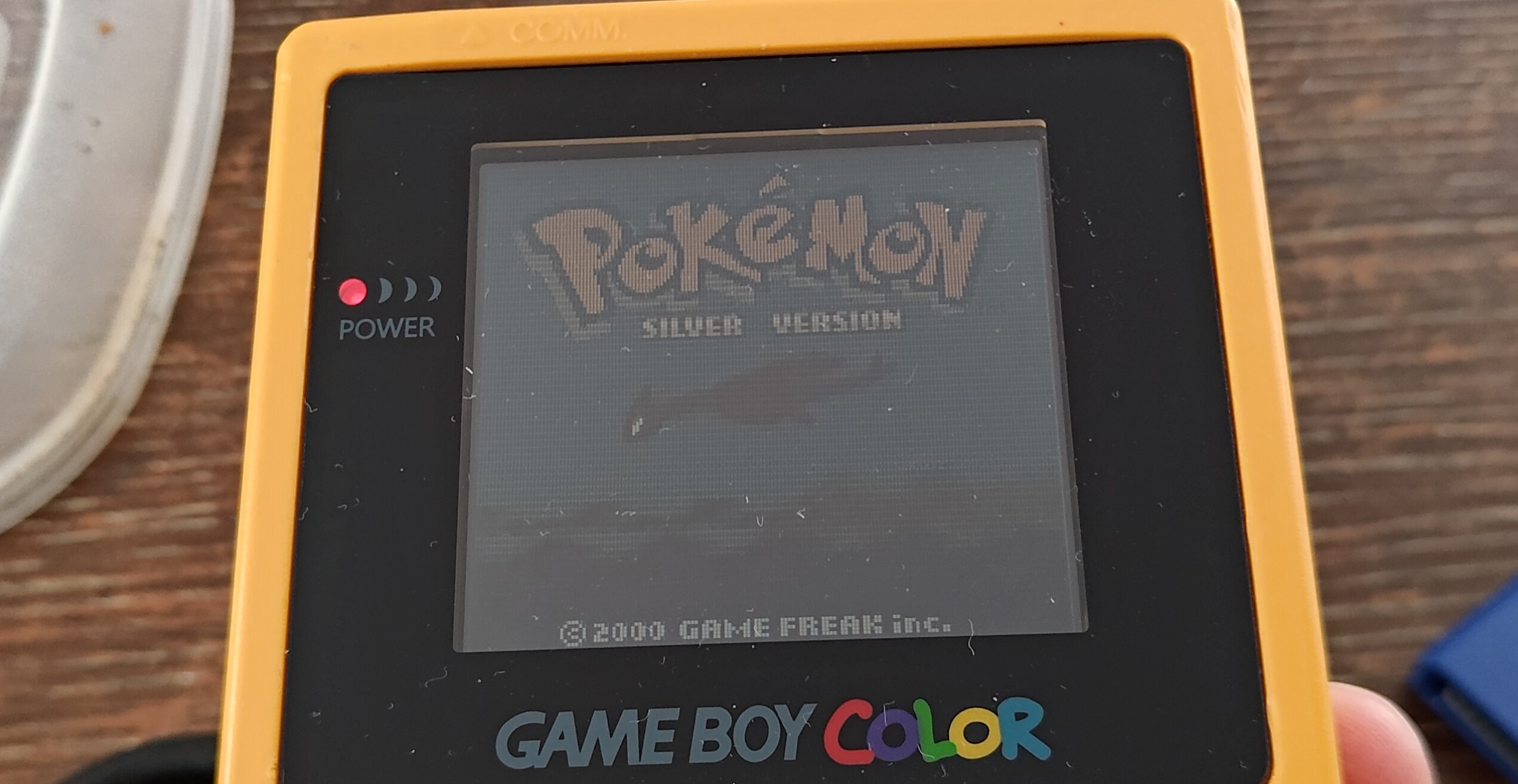 A yellow GameBoy Color screen showing the title screen for Pokémon Silver