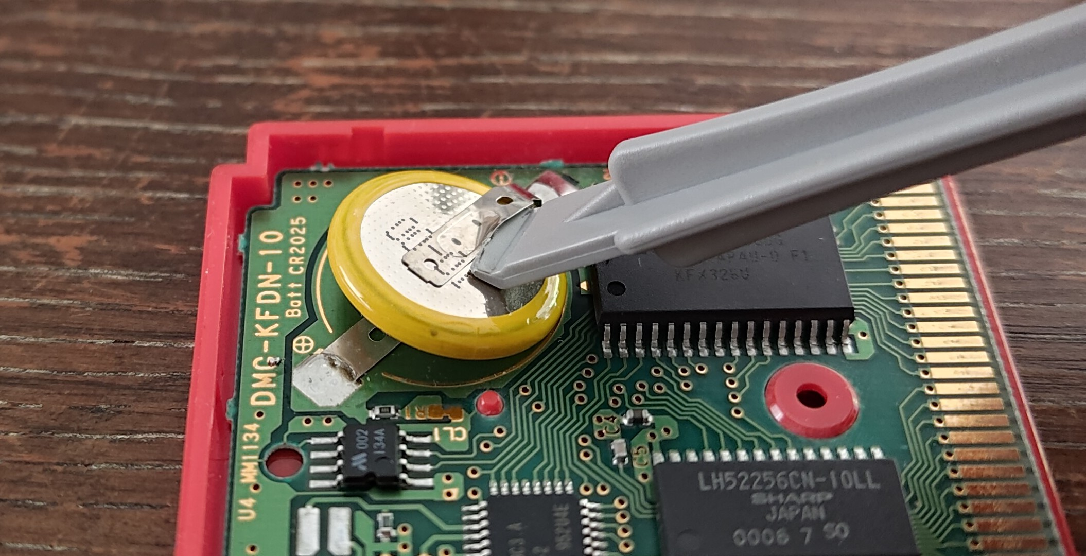 Using a plastic pry tool under the tabs to bend and ultimately detach them from the battery